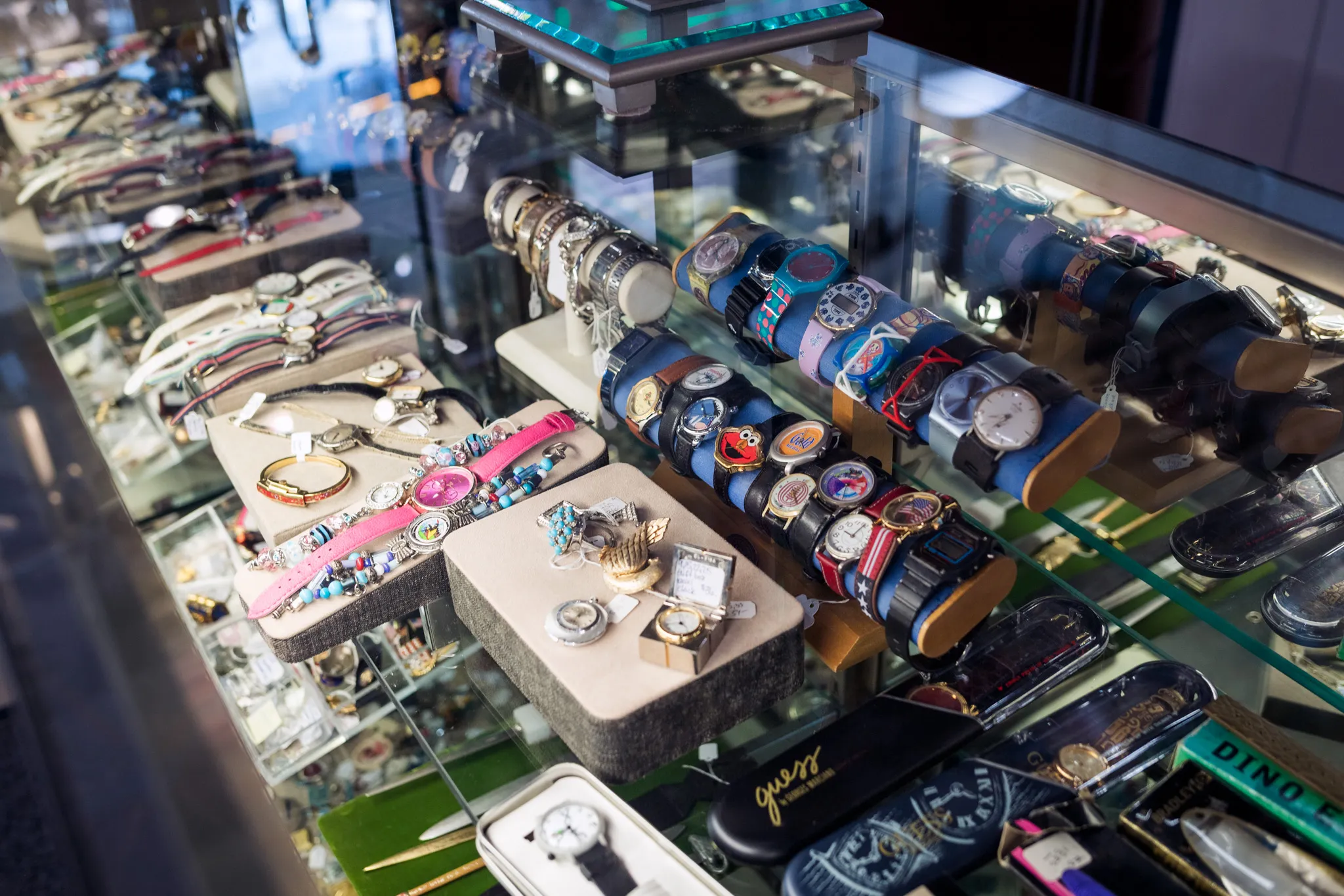 Display case with assorted watches and bracelets.