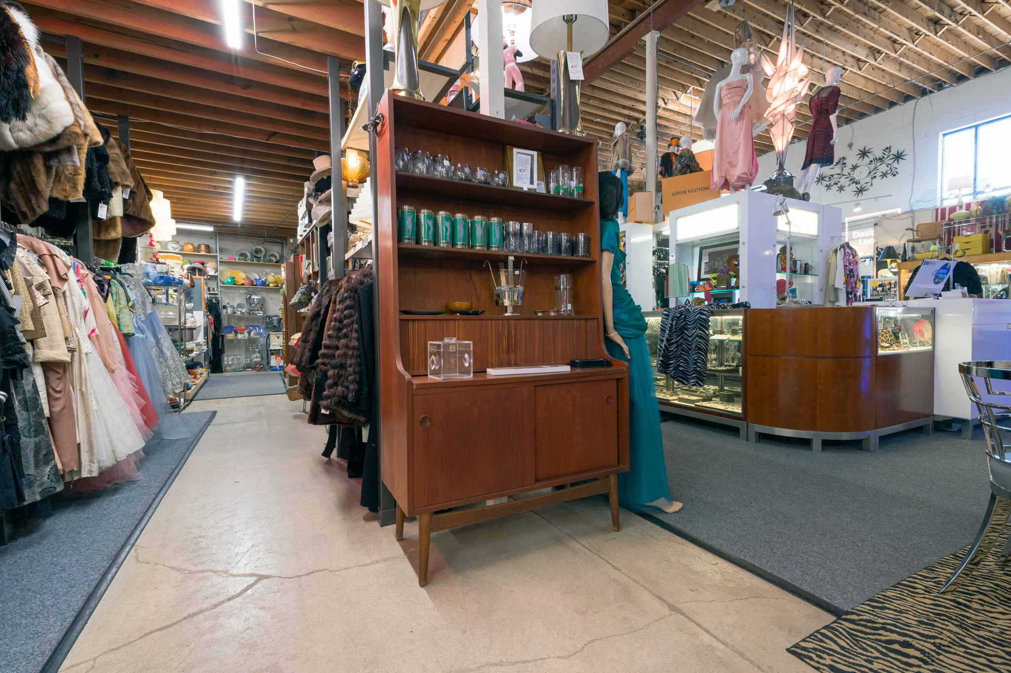 Vintage shop interior with clothing and furniture.