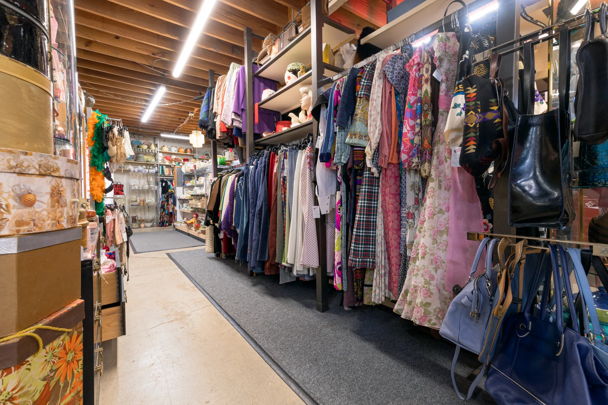 Thrift store aisle with clothes and accessories.