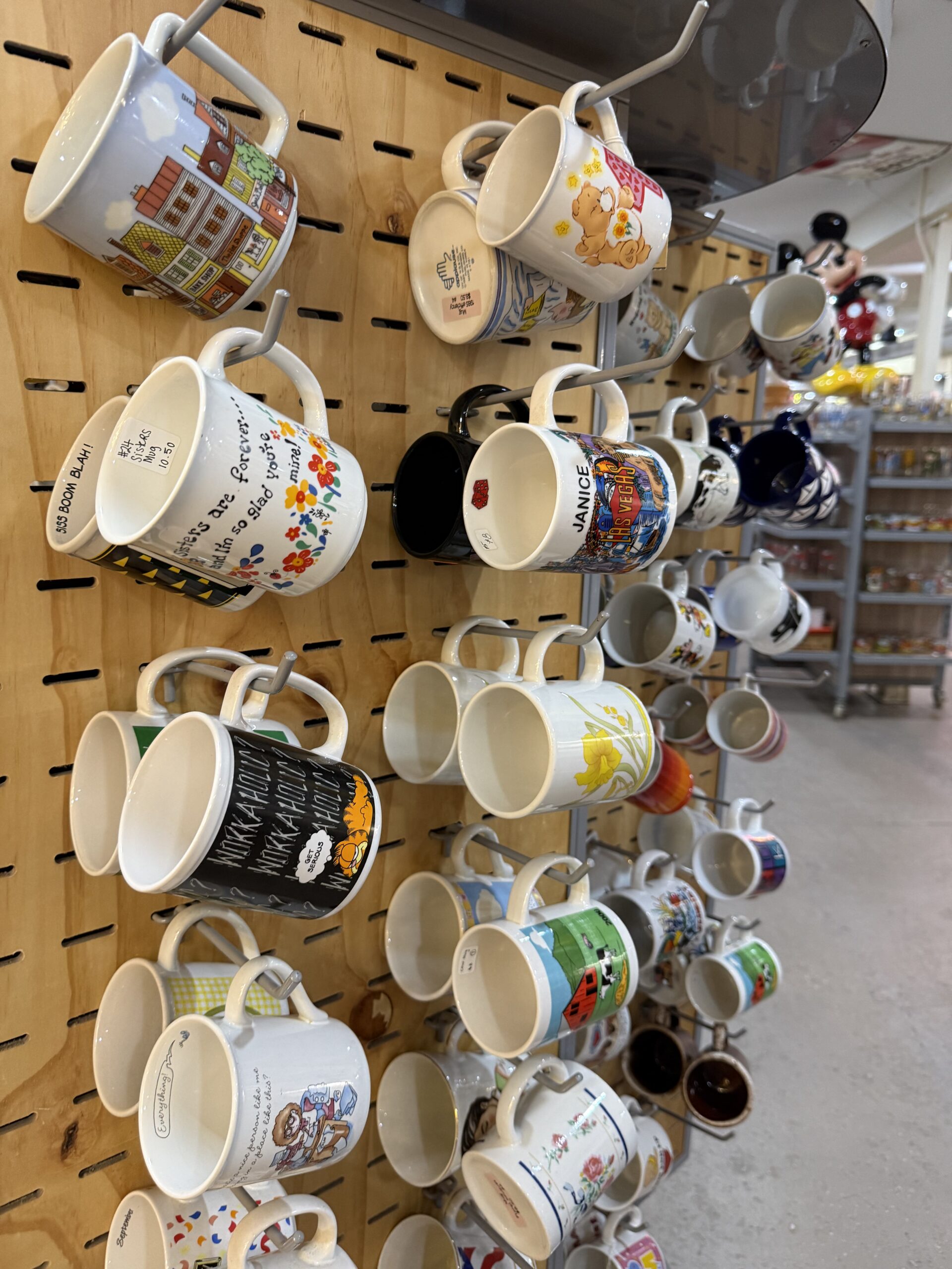 Assorted mugs displayed on a wooden rack.